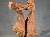 sculpture of two women holding hands on a wooden base