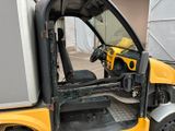 a small yellow truck with a door open in a parking lot