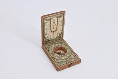 a small wooden box with a compass inside of it