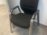 a black office chair sitting in a corner of a room