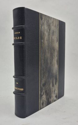 un livre noir orné de lettres dorées, posé sur une surface blanche