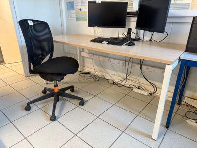 a desk with two computer monitors on it and a chair in front of it