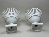 pair of white porcelain wall sconces with a decorative design
