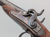 a close up of a gun with a wooden handle on a white background
