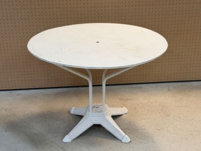 une table blanche avec un plateau blanc posée sur un sol en ciment