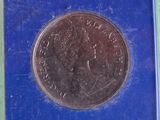 a close up of a coin in a blue box on a green surface