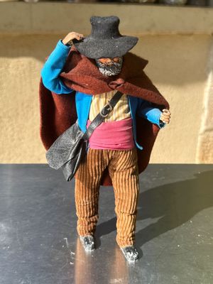 a small figurine of a man with a hat and jacket