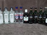 de nombreuses bouteilles d'alcool posées sur une chaise à côté d'un carton de spiritueux