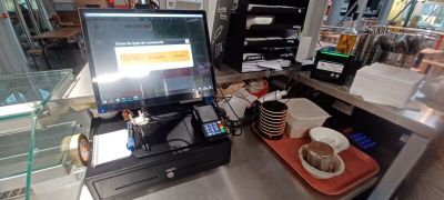 un ordinateur portable posé sur le comptoir d'un café