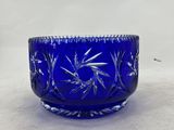 a close up of a blue glass bowl on a white surface