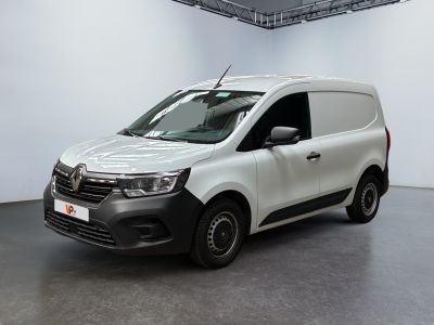 La camionnette blanche est garée dans une grande pièce au sol noir
