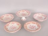 four pink and white plates with pink flowers on them on a table