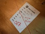 a receipt sitting on a wooden table with a red string