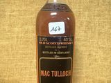 une vieille bouteille de Mac Tulloch posée sur une table