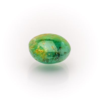 a close up of a green stone on a white surface
