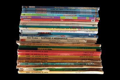 a lot of children ' s books stacked on top of each other