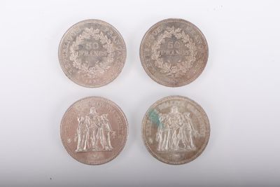 quatre types de pièces différents sur une surface blanche