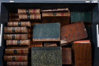 de nombreux livres anciens dans une boîte noire posée sur une table