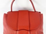 a red leather handbag with a bow on the handle