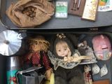 une valise remplie de jouets et d'autres objets, posée par terre