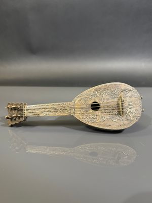 un instrument de musique ancien plaqué argent posé sur une table