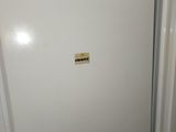 a white refrigerator in a kitchen with a trash can on top of it