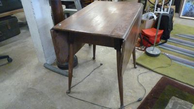 une table en bois avec un tiroir, placée au milieu d'une pièce