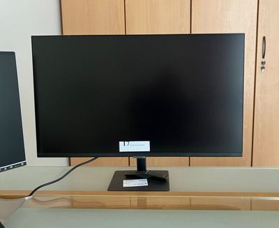 a computer monitor sitting on top of a desk next to a computer monitor