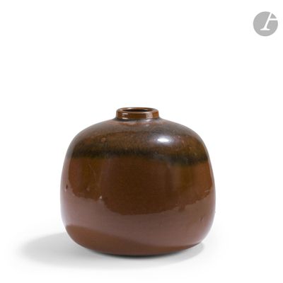 a brown vase that is sitting on a white surface