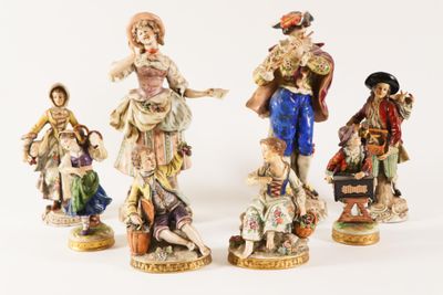 three figurines of people dressed in different styles of clothing