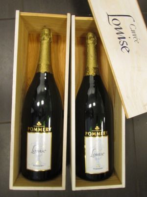 deux bouteilles de champagne dans un coffret en bois posé sur une table