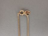 a picture of a gold chain with a heart on it