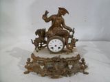 une horloge posée sur une table et surmontée d'une statue