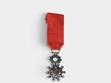 gros plan d'une médaille sur une surface blanche avec un ruban rouge