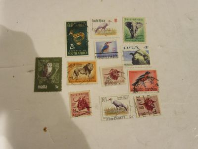 many different stamps on a table with a shadow of a person