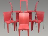 six chaises rouges disposées en cercle sur un fond gris