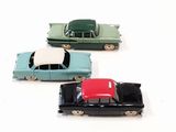 several toy cars are lined up in a row on a white surface