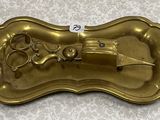 a gold tray with a pair of scissors on it