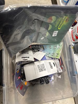 un bac en plastique posé par terre et rempli d'objets divers