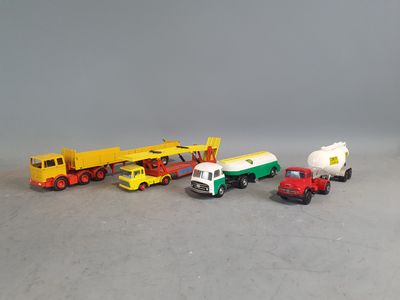several toy trucks are lined up in a row on a gray surface