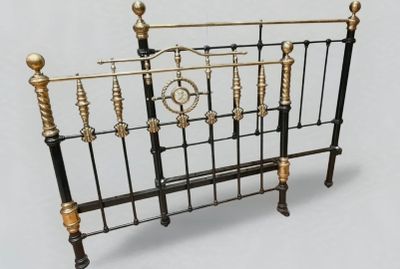 un lit avec un cadre en métal et une horloge sur la tête de lit