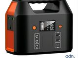 un chargeur portable orange et noir posé sur une surface blanche