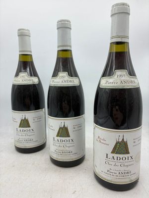 trois bouteilles de vin rouge sont alignées sur une table