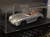 a silver toy car in a clear box on a shelf