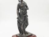 a bronze statue of a woman holding a child on a marble base