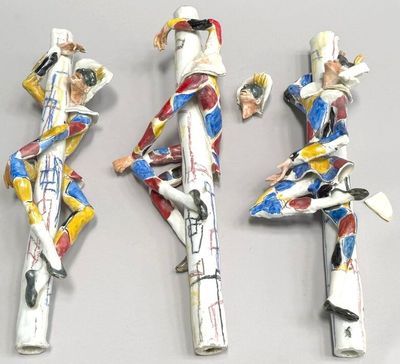three figurines of a woman in a dress and a man in a suit