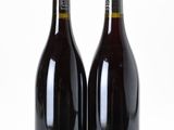 two bottles of wine sitting next to each other on a table