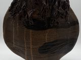 a wooden vase with a brown and black design on it