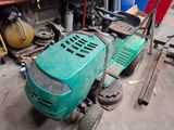 une tondeuse à gazon verte rangée dans un garage