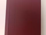 un livre rouge posé sur une table blanche